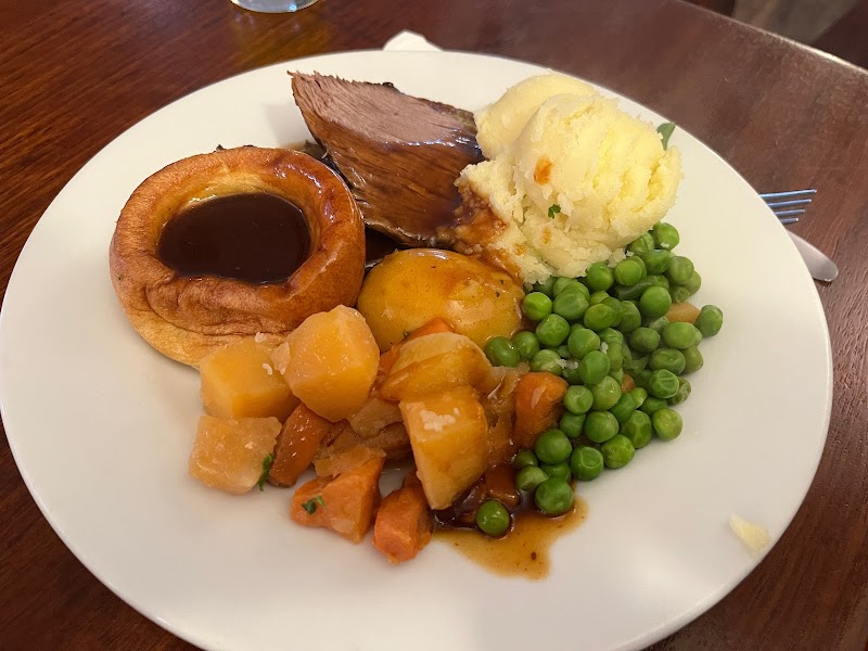 Classic Sunday roast plate with Yorkshire pudding, roast beef, mash and peas